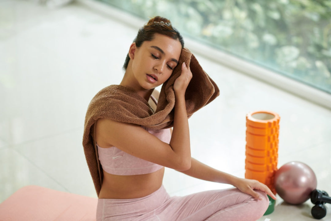 Woman towelling off after a workout, staying fresh in humid tropical heat with aluminium-free natural deodorant.