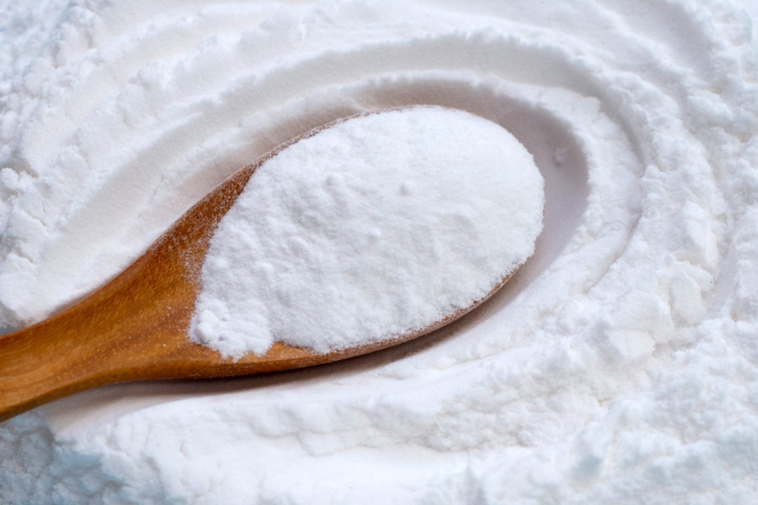 Baking soda in a metal spoon, the irritating ingredient to avoid in deodorant for sensitive underarm skin.